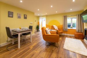 a living room with a table and chairs and a couch at Heulog Cottage - King Bed, Self-Catering with Private Hot Tub in Bodfari