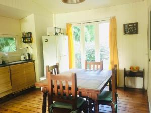 a kitchen with a wooden table with chairs and a refrigerator at Verde Lujan Delta in Tigre