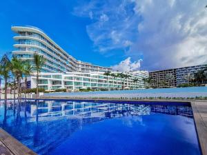 a large building with a swimming pool in front of it at Area Ocean vista al mar in Nuevo Vallarta