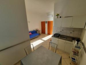 a kitchen with a table and a blue couch at Apartments Rose in Lokva Rogoznica