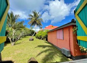 a colorful house with a yard next to it at Maison charmante avec piscine - Sainte-Rose in Sainte-Rose +7 photos