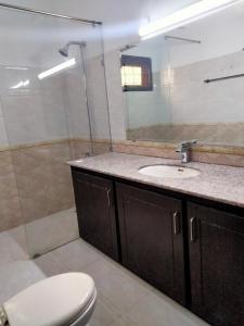 Un baño con inodoro, lavabo y espejo. en Dazzy Dream Guest Houses, en Islamabad