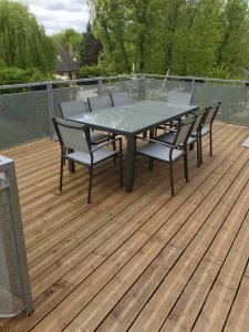 une table et des chaises sur une terrasse en bois dans l'établissement Maison de 3 chambres avec jardin clos et wifi a Chavot Courcourt, à Chavot-Courcourt