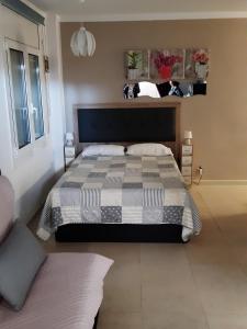 a bedroom with a bed with a black and white comforter at CLUB NAUTIC 3 in Empuriabrava