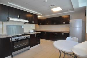 a kitchen with wooden cabinets and a white table in it at Elegance hostel in Dubai