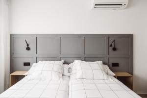 A bed or beds in a room at Exclusive Rooms in the Heart of the City