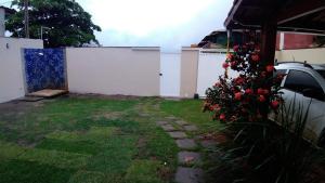 a backyard with a white fence and a yard at Casa Praia 1000 - Guriri Norte in São Mateus
