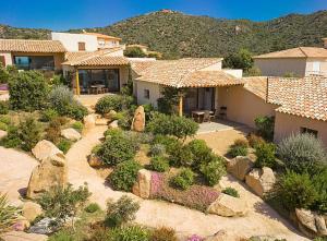 a house with a garden with rocks and plants at Résidence A Rundinella in Porto-Vecchio