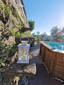 una linterna sentada en una pared de piedra junto a una piscina en Casa da Colina, en Amarante