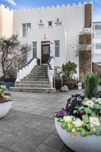 un edificio con escaleras y flores delante en Castle House Luxury Apartments en Reikiavik