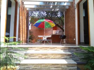 a colorful umbrella on a patio with a table at Eden Garden Farm Stay in Auroville +11 photos