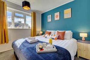 ソウザンにあるInspire Homes 2-Bed Sleeps 5 near Leamington & M40の青いベッドルーム(ベッド1台、食料トレイ付)