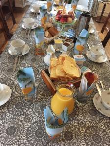 a table with a breakfast of bread and orange juice at Les hortensias in Grand-Fougeray