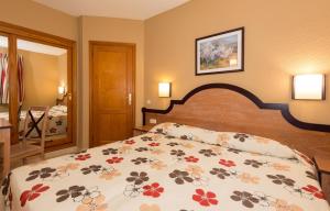 een slaapkamer met een bed met een bloemenbed bij Apartamentos El Beril Costa Adeje in Adeje