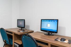 a desk with a computer and a monitor on it at Bandeirantes Hotel in Cuiabá