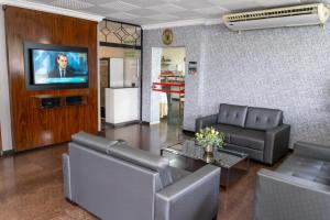 a living room with two couches and a tv at Bandeirantes Hotel in Cuiabá