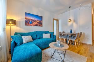 茲拉蒂博爾的住宿－Apartman Berolina 2，客厅配有蓝色的沙发和桌子