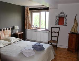 1 dormitorio con 1 cama, 1 silla y 1 ventana en Le Dô d'Anne en Villetritouls