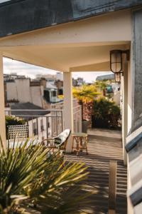 eine Terrasse mit einem Stuhl und einem Tisch auf dem Balkon in der Unterkunft Hotel Eiffel Blomet in Paris