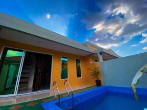 a villa with a swimming pool and a house at Tokman Inn in Pantai Cenang