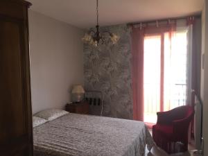 a bedroom with a bed and a window and a chair at Le Casone in Ajaccio