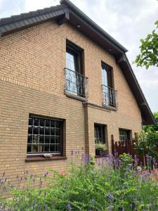 une maison en briques avec des fenêtres et des fleurs dans l'établissement Ferienwohnung auf dem Eltenberg, à Elten