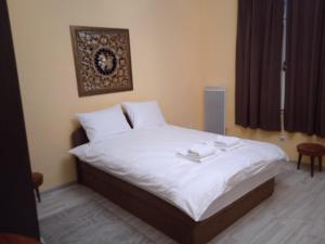 a bedroom with a white bed with a picture on the wall at Bajloni lux in Belgrade +16 photos