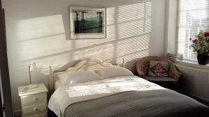 a bedroom with a bed and a chair and a window at 38 Newtown in Bradford on Avon