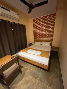 a bedroom with a bed and a chair in it at Hotel Vardhan in Silvassa
