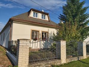 a white house with a fence and a tree at Chalupa u Valiky in Podtureň