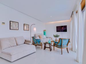 sala de estar blanca con sofá y sillas en Vale do lobo, 'Golf by the Pool' 2 bedroom apartment, en Vale do Lobo