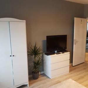 ein Wohnzimmer mit einem TV auf einer weißen Kommode in der Unterkunft Flensburg Strandnah in Flensburg