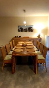 a dining room table with chairs and a wooden table with food on it at Maison et vélos à Godinne dans la Vallée de la Meuse in Godinne