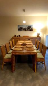 een eettafel met stoelen en een houten tafel met eten erop bij Maison et vélos à Godinne dans la Vallée de la Meuse in Godinne