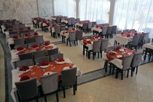 法耶德的住宿－Jewel Fayed Hotel，一间用餐室,配有桌椅和红色玫瑰