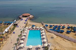 een luchtzicht op een strand met een zwembad en parasols bij Jewel Fayed Hotel in Fayed