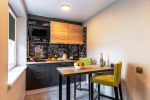 a kitchen with a wooden table and yellow chairs at Отель Сочи in Sochi