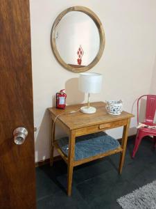 a table with a lamp and a mirror on a wall at Casa Inés in Trinidad