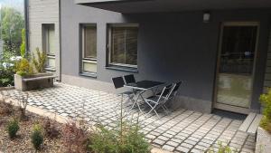 patio ze stołem i krzesłami przed domem w obiekcie Apartment Draco w mieście Harrachov