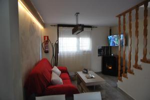 sala de estar con sofá rojo y chimenea en El Arroyo en Los Narros