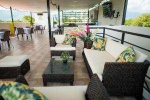 un patio con sofás blancos y una mesa con flores en Solaris Hotel, en Villavieja