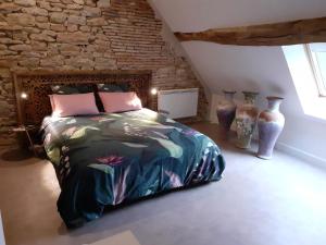 1 dormitorio con 1 cama y algunos jarrones en De Pierre et de Lumière, en Jouhe