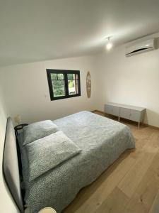 een witte slaapkamer met een bed met 3 kussens bij Villa Chantaco Bassin Arcachon in Gujan-Mestras