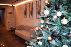 a christmas tree in a living room with a couch at Отель Сочи in Sochi
