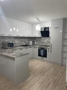 a kitchen with white cabinets and a wooden floor at Emily & Nasi in Plovdiv +7 photos