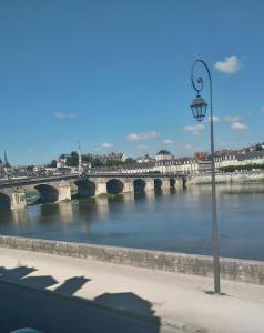 a bridge over a river with a street light at La petite maison du Quai in Blois