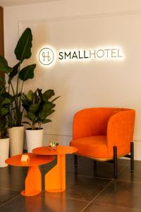an orange chair and a table in a room at SMALL HOTEL in Vinnytsya