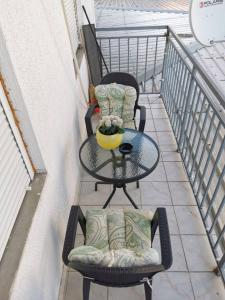 un balcón con 2 sillas y una mesa en el balcón en Lux Apartman Krstic, en Kruševac