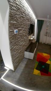 - un salon avec un mur en briques et un canapé dans l'établissement Hotel Marasesti, à Buşteni