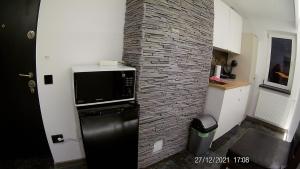 a kitchen with a brick wall and a microwave at Hotel Marasesti in Buşteni